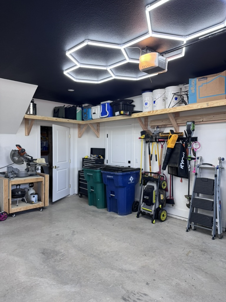 Organized garage after the TrueCraft transformation with hex lighting and overhead shelving